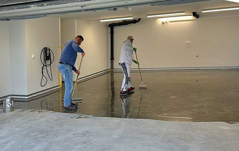Arbeiter beim Bodenbeschichten mit Epoxidharz
